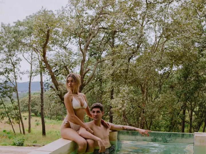 Pareja en alberca rodeada de bosque